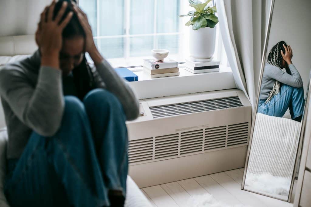 young woman in bedroom upset