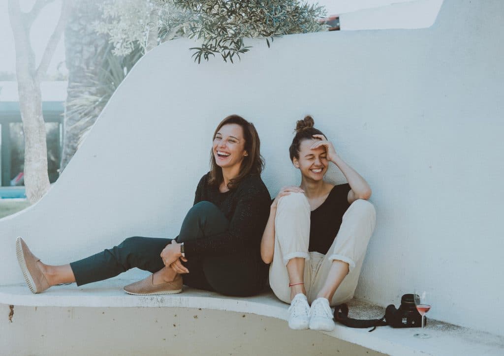two women sitting and smiling together