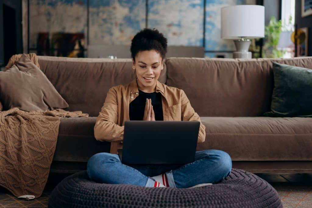 woman sitting on couch reading her laptop